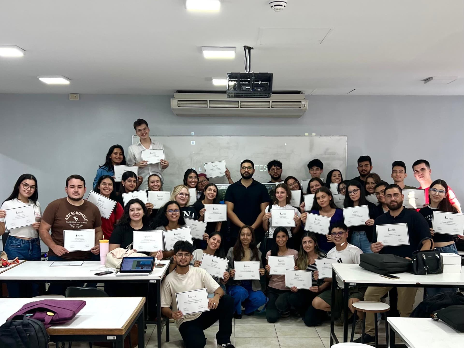 Estudiantes de IMUTES con sus certificados de finalización de curso
